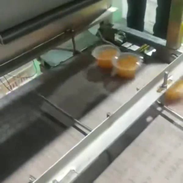 Vasos sellados pasando por la cámara de inspección de sellado con IA